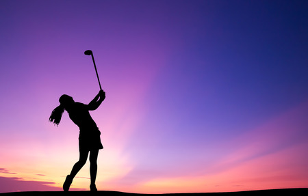 silhouette golfer playing golf during beautiful sunsetの写真素材