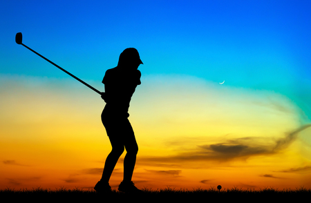 silhouette golfer playing golf during beautiful sunsetの写真素材