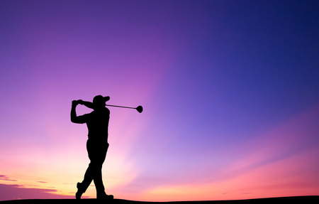 silhouette golfer playing golf during beautiful sunsetの写真素材