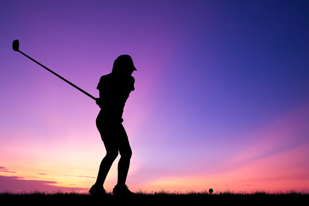 silhouette golfer playing golf during beautiful sunsetの写真素材