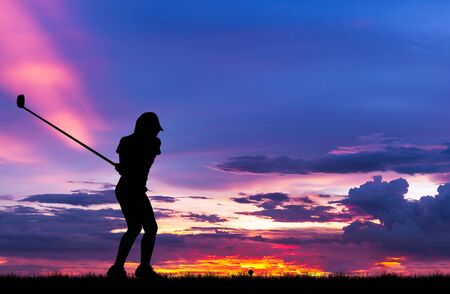silhouette golfer playing golf during beautiful sunsetの写真素材