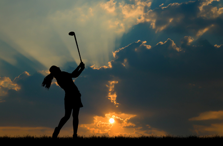silhouette golfer playing golf during beautiful sunsetの写真素材