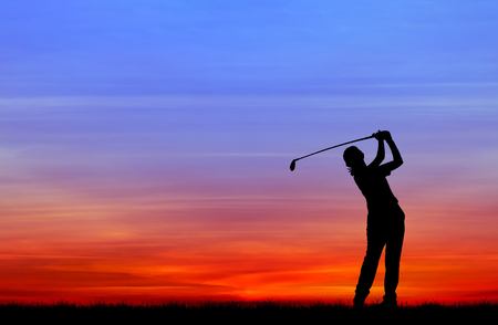 silhouette golfer playing golf during beautiful sunsetの写真素材