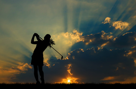 silhouette golfer playing golf during beautiful sunsetの写真素材