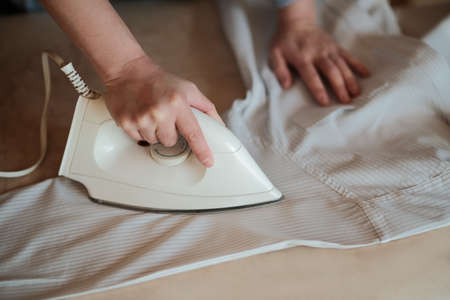 woman ironing shirt at home