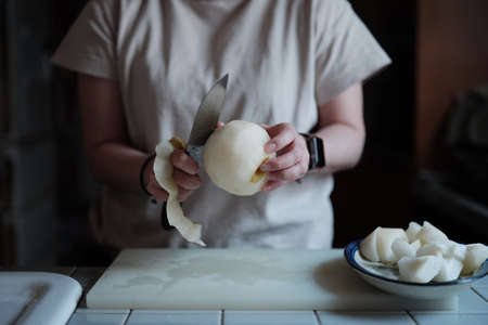 woman who cut pear in the kitchenの写真素材