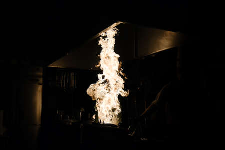 FlambÃ© in the dark kitchen