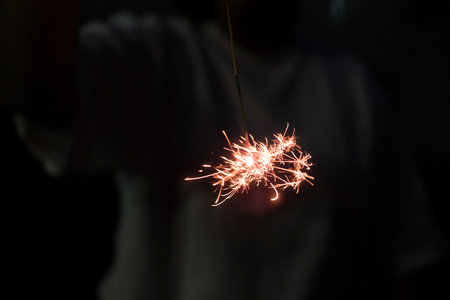 boy holding fireworks in night