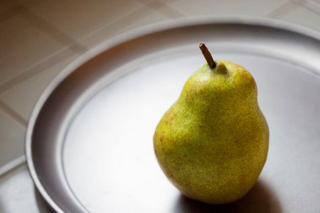 one pear on silver dishの写真素材