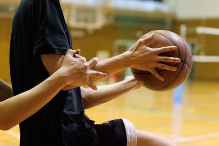 People practicing basketball in a gymの写真素材