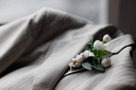 Wedding boutonniere with white flowers on the groom's suit