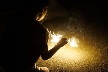 Young woman holding burning sparklers in her hands. Selective focusの写真素材