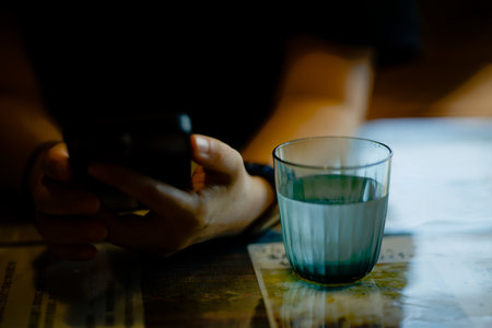 Glass of water and woman's arm