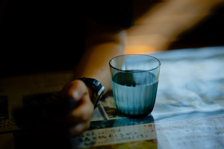 Glass of water and woman's armの写真素材