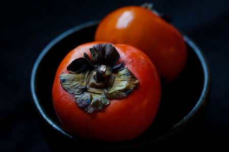 Persimmon on the black tableの写真素材