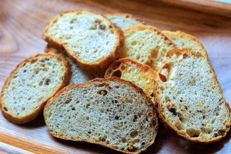 Slices of bread on a wooden plate. Selective focus.