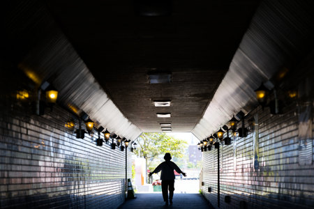 Rear view of a person running in a tunnel at night.の写真素材