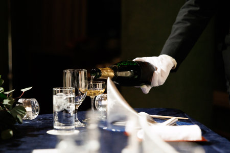 waiter pouring champagne in partyの写真素材