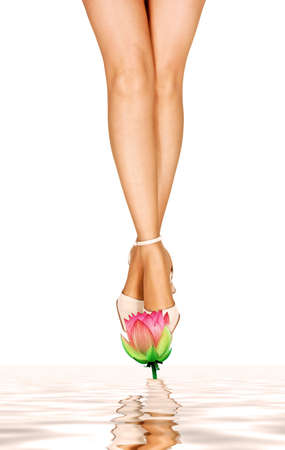 Beautiful woman's legs with lotus flowerの写真素材