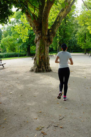 Young beautiful caucasian woman jogging in summer park の写真素材