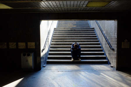 Lonely man sitting on the stairsの写真素材