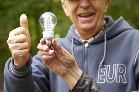 Senior man showing eco diode bulbの写真素材