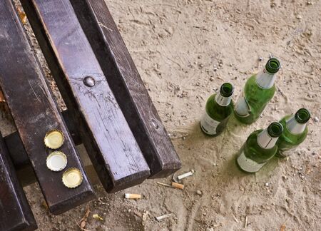 Beer bottles on benches in the parkの写真素材