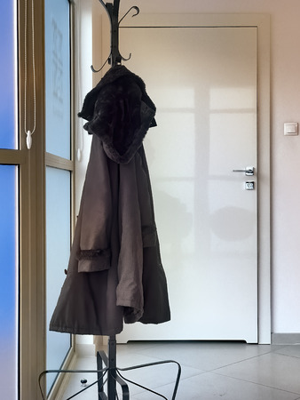 Menâs coat hanging in empty officeの写真素材