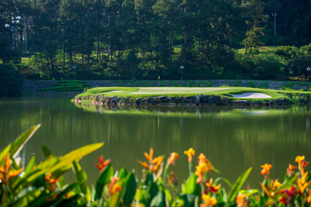 Golf course with green grass and beautiful lake in the morning.の写真素材