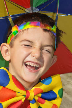 Happy child with colorful sunshade and bow tieの写真素材