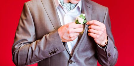 A groom putting on cuff-links as he gets dressed in formal wear .Groom's suitの写真素材
