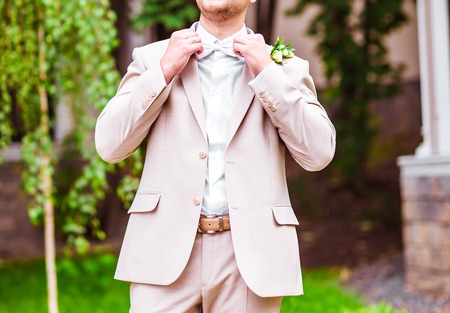 A groom putting on cuff-links as he gets dressed in formal wear .Groom's suitの写真素材