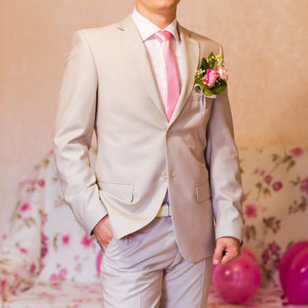A groom putting on cuff-links as he gets dressed in formal wear .Groom's suitの写真素材