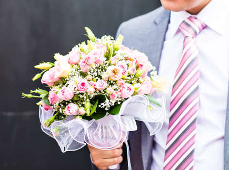 A groom putting on cuff-links as he gets dressed in formal wear .Groom's suitの写真素材