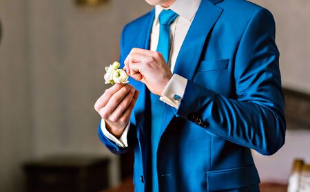 Posed groom with rose button hole.Wedding details, beautiful boutonniere, men's detailsの写真素材