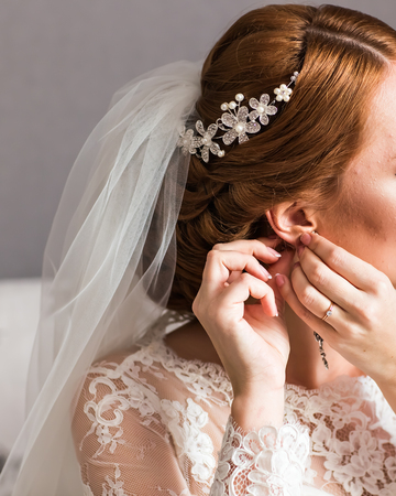 Morning bride. Beautiful bride wears earrings. Wedding dayの写真素材