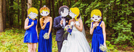 wedding party,  groomsmen and bridesmaids wearing masks in natureの写真素材