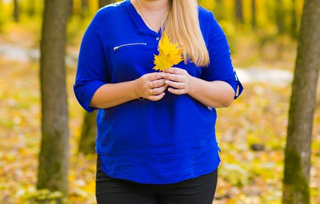young girl walking in autumn park on yellow leavesの写真素材