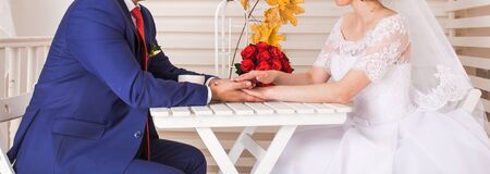 Bride and groom holding  hands  and a bunch of autumn mapleの写真素材