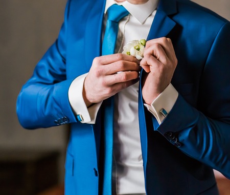 Groom wearing boutonniere. Groom wears a weddingの写真素材