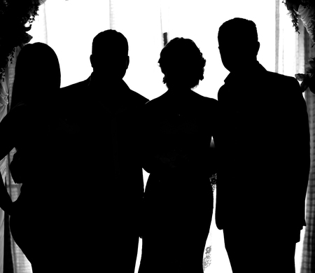 silhouette of the bride and groom and guests at a wedding.の写真素材