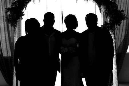 silhouette of the bride and groom and guests at a wedding.の写真素材