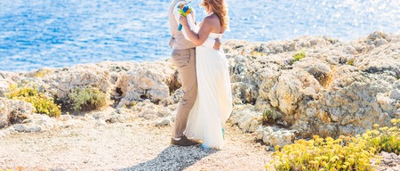 Bride and groom by the sea on their wedding dayの写真素材