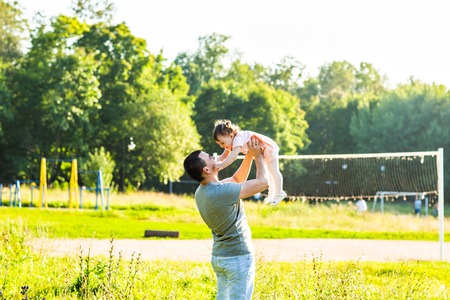 Little baby girl in a summer park with her fatherの写真素材