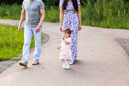 Happy Young Mixed Race Ethnic Family Walking In The Park.