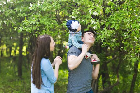 Happy young family spending time together in green nature.の写真素材
