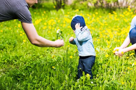 Happy young family spending time together in green nature.の写真素材
