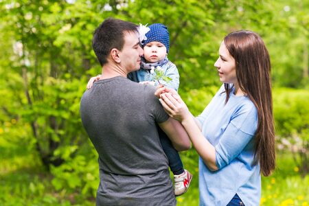 Happy young family spending time together in green nature.