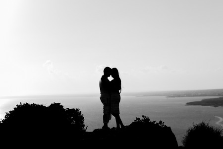 silhouette happiness and romantic scene of love couples partners on top of the mountainの写真素材
