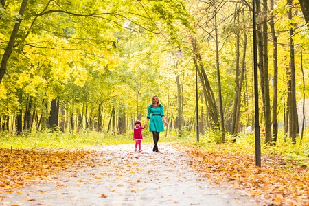 mother with her daughter for a walk in autumn parkの写真素材